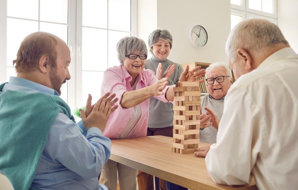 Eine Gruppe älterer Leute spielt Jenga.