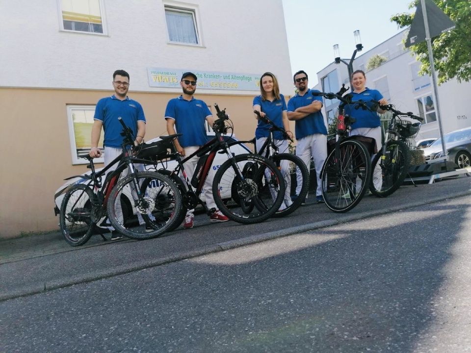Teambild mit Fahrrad Pflegedienst Vitalis