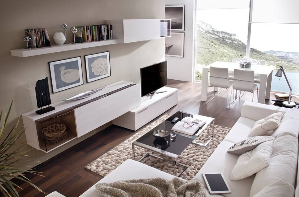 Sala de estar moderna con muebles blancos, TV y comedor. Vista a la montaña.