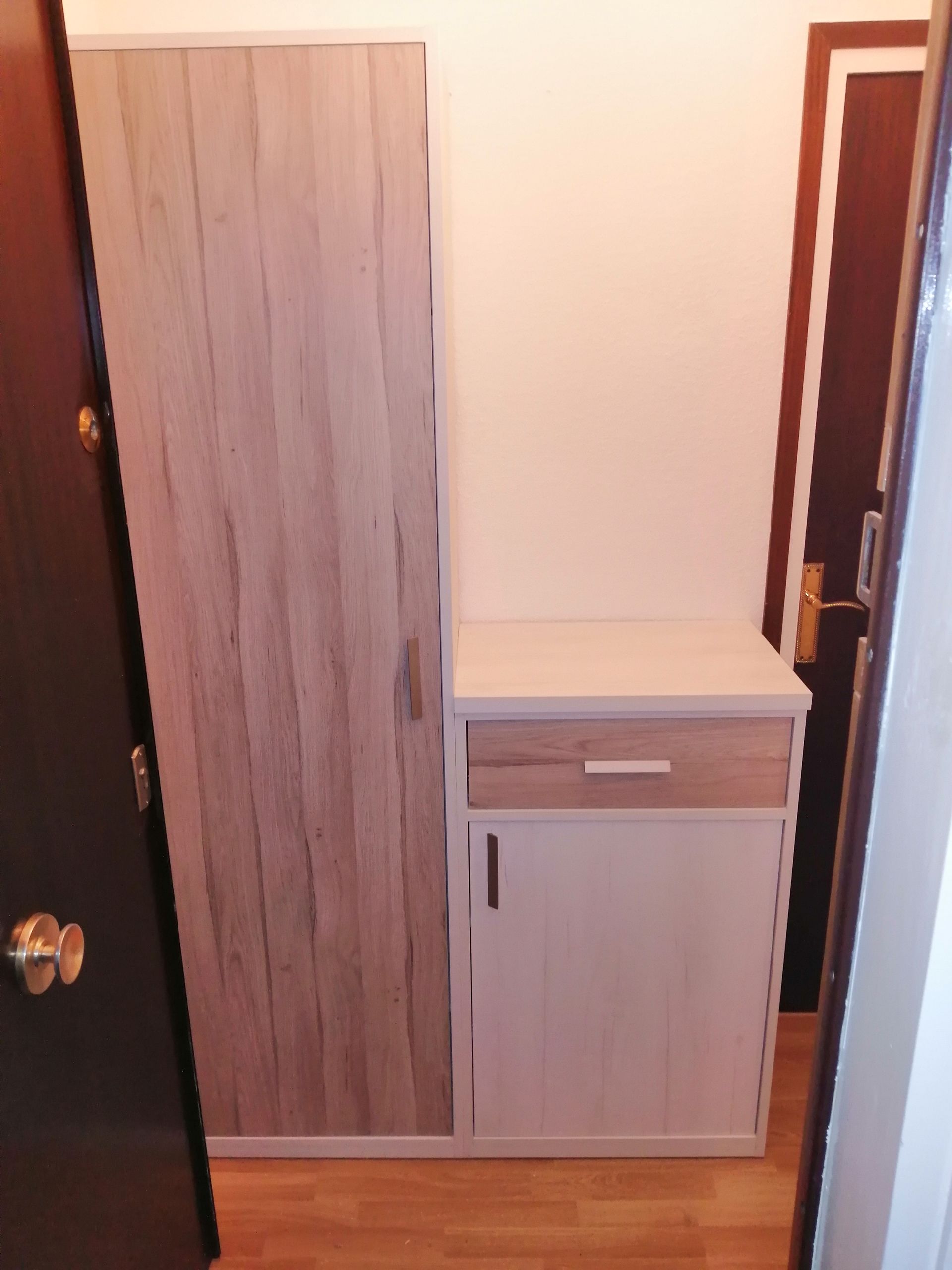 Armario de madera y mueble de entrada. El mueble tiene cajón y puerta.