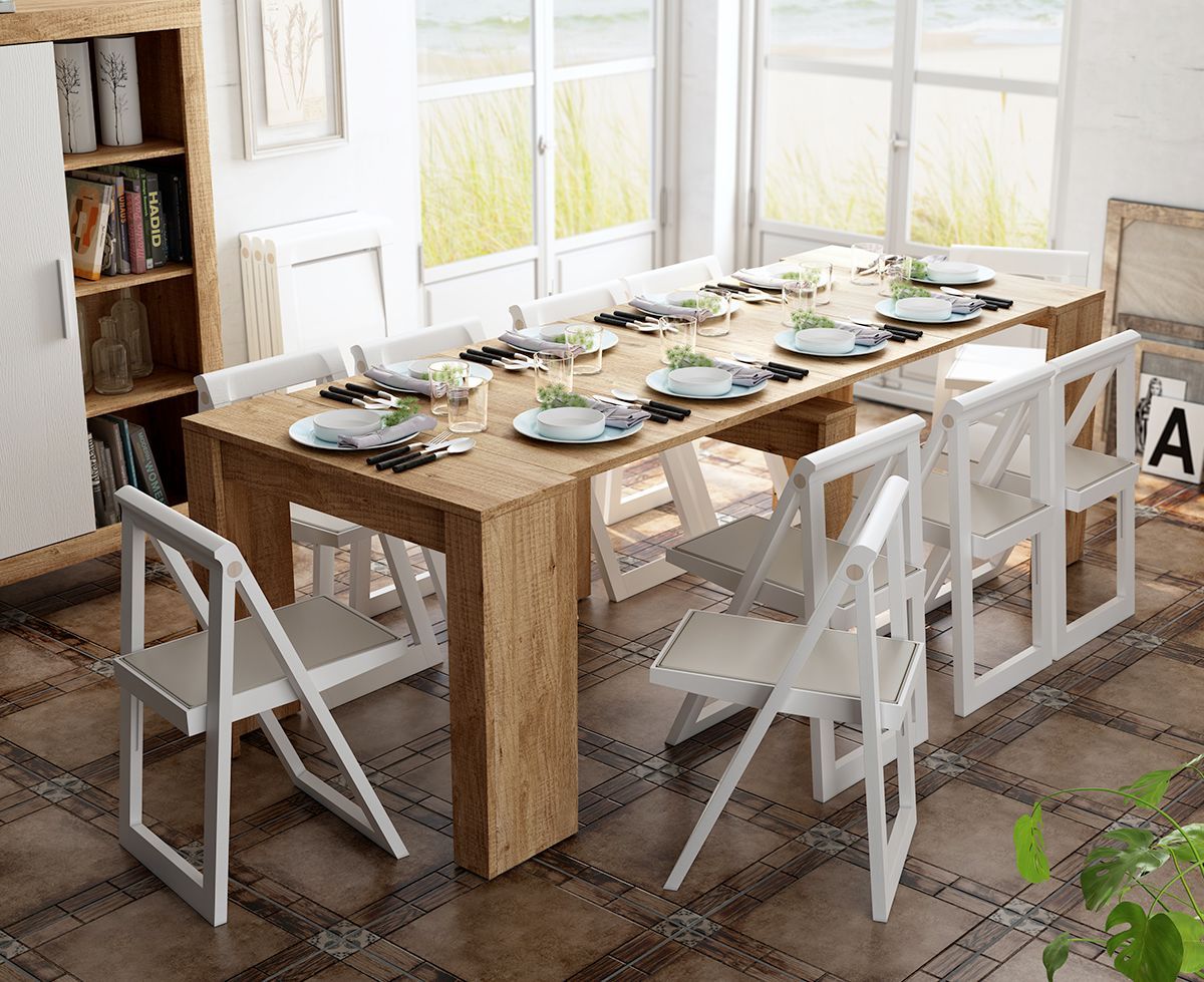 Una gran mesa de comedor de madera con sillas blancas plegables, en el interior. La mesa está preparada para comer.
