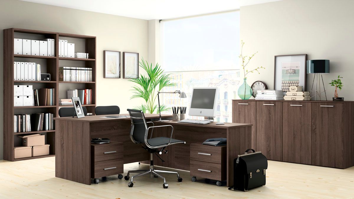 Oficina con escritorio, librería y armarios de madera oscura. Silla negra, documentos y un portátil.