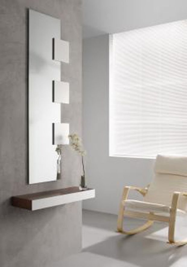 Espejo de pared moderno con estante, junto a mecedora y ventana con persianas.