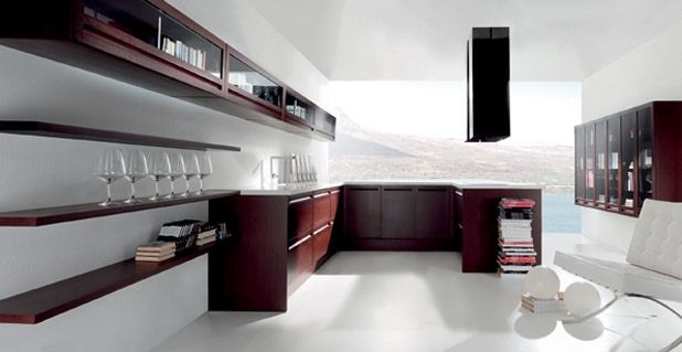 Cocina moderna y minimalista con gabinetes oscuros, estantes flotantes y paredes y pisos blancos.