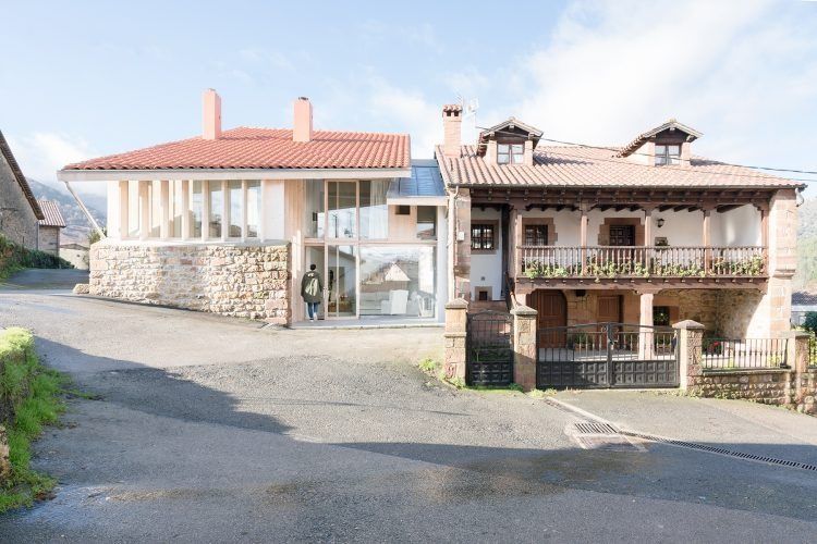 Dos casas están una al lado de la otra al costado de una carretera