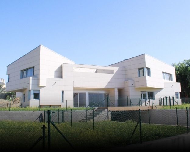 Una gran casa blanca con una valla alrededor.