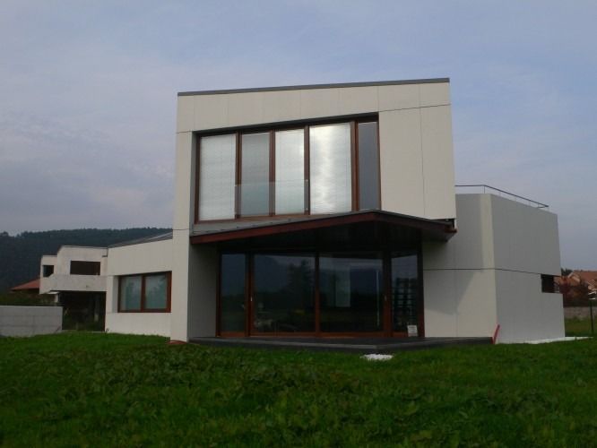 Una casa blanca con muchas ventanas y un balcón.