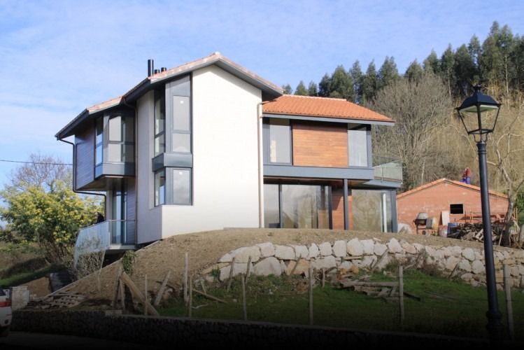Una casa con techo de tejas rojas y muchas ventanas
