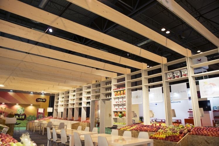 Una gran sala con mesas y sillas llenas de frutas y verduras.