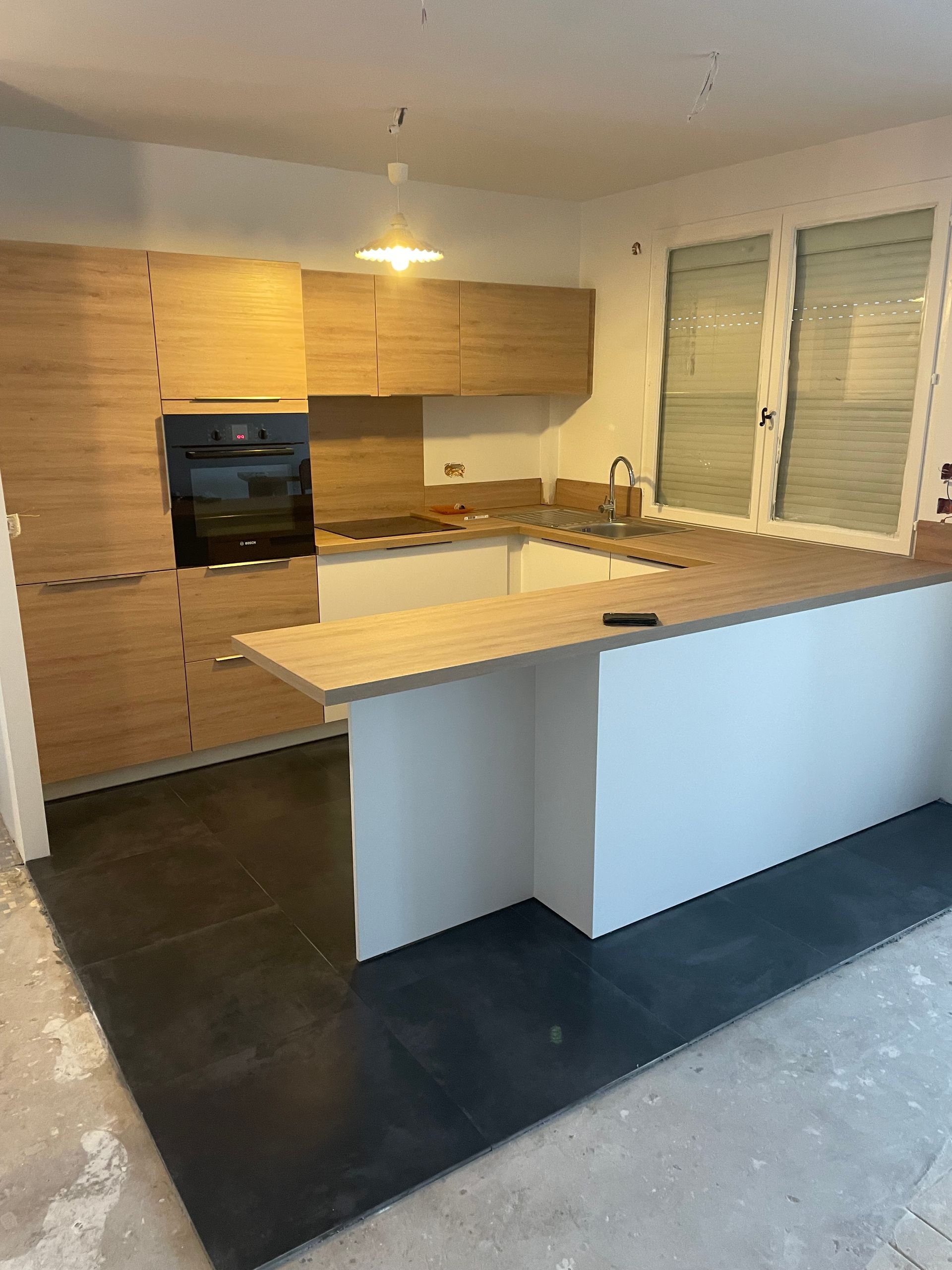 Une cuisine rénovée avec un grand plan de travail en bois.