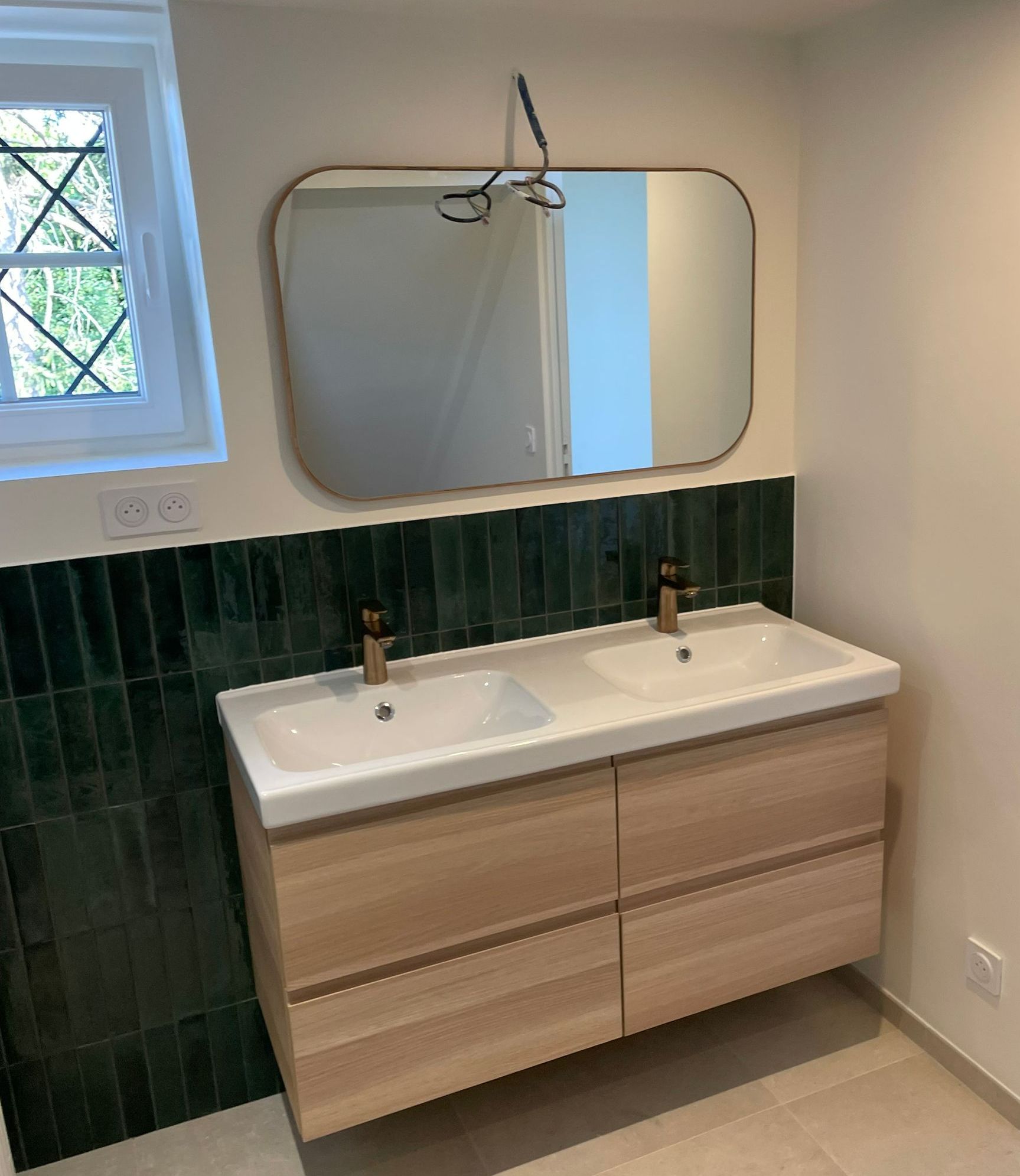 Deux vasques sous un grand miroir dans une salle de bains moderne.