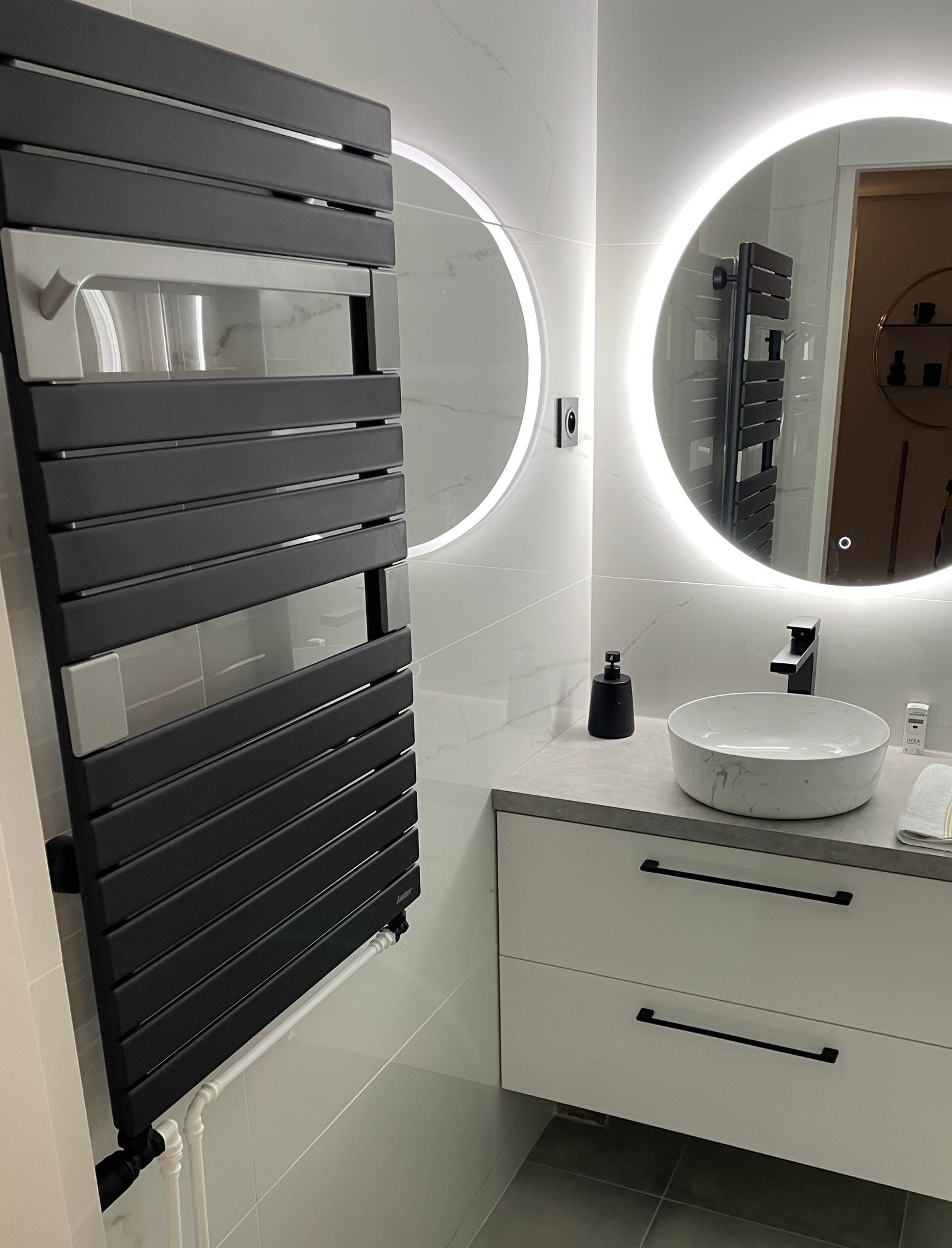 Une salle de bains entièrement rénovée avec une baignoire et de la faïence beige.