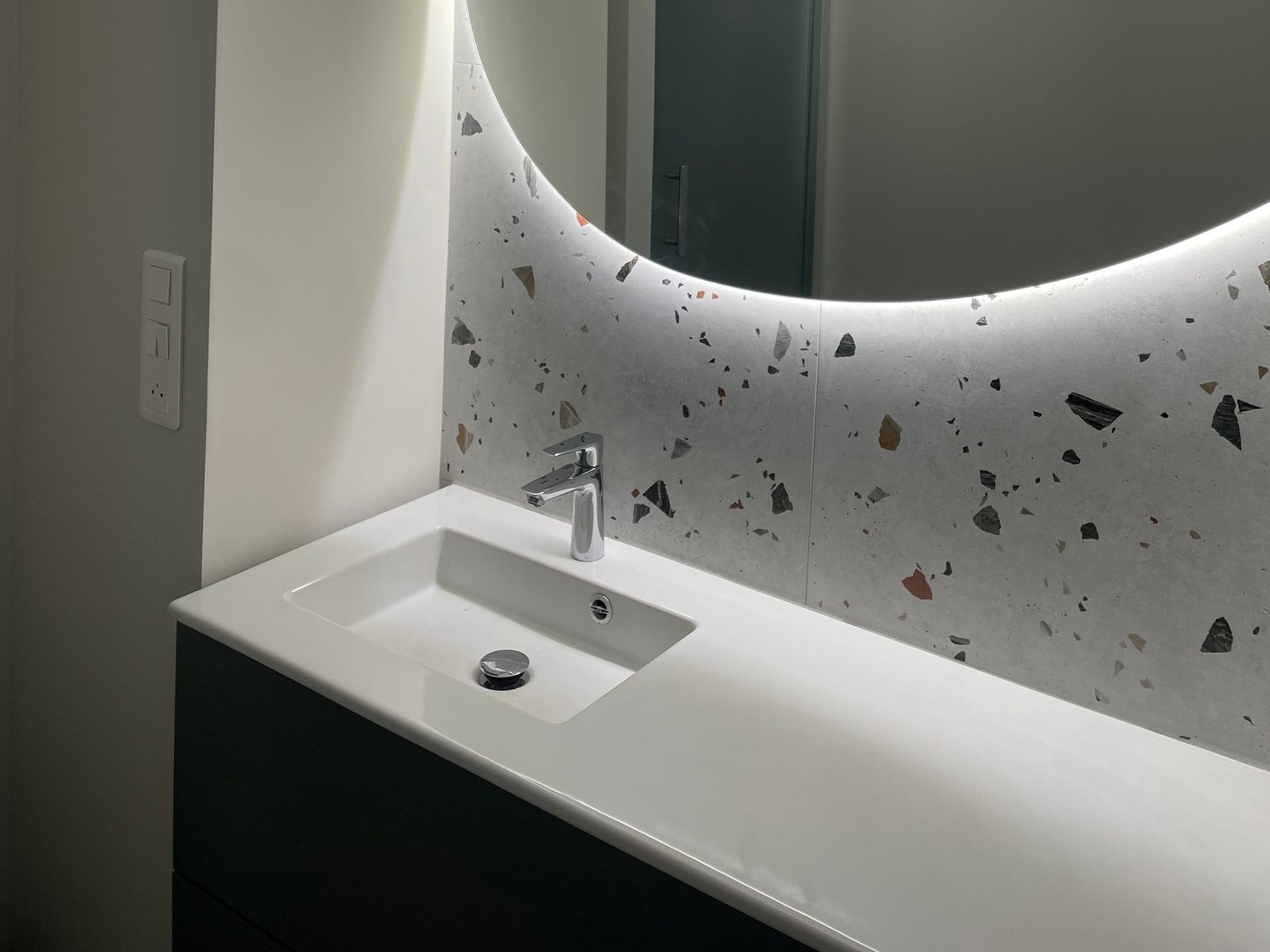 Un lavabo sous un miroir éclairé.