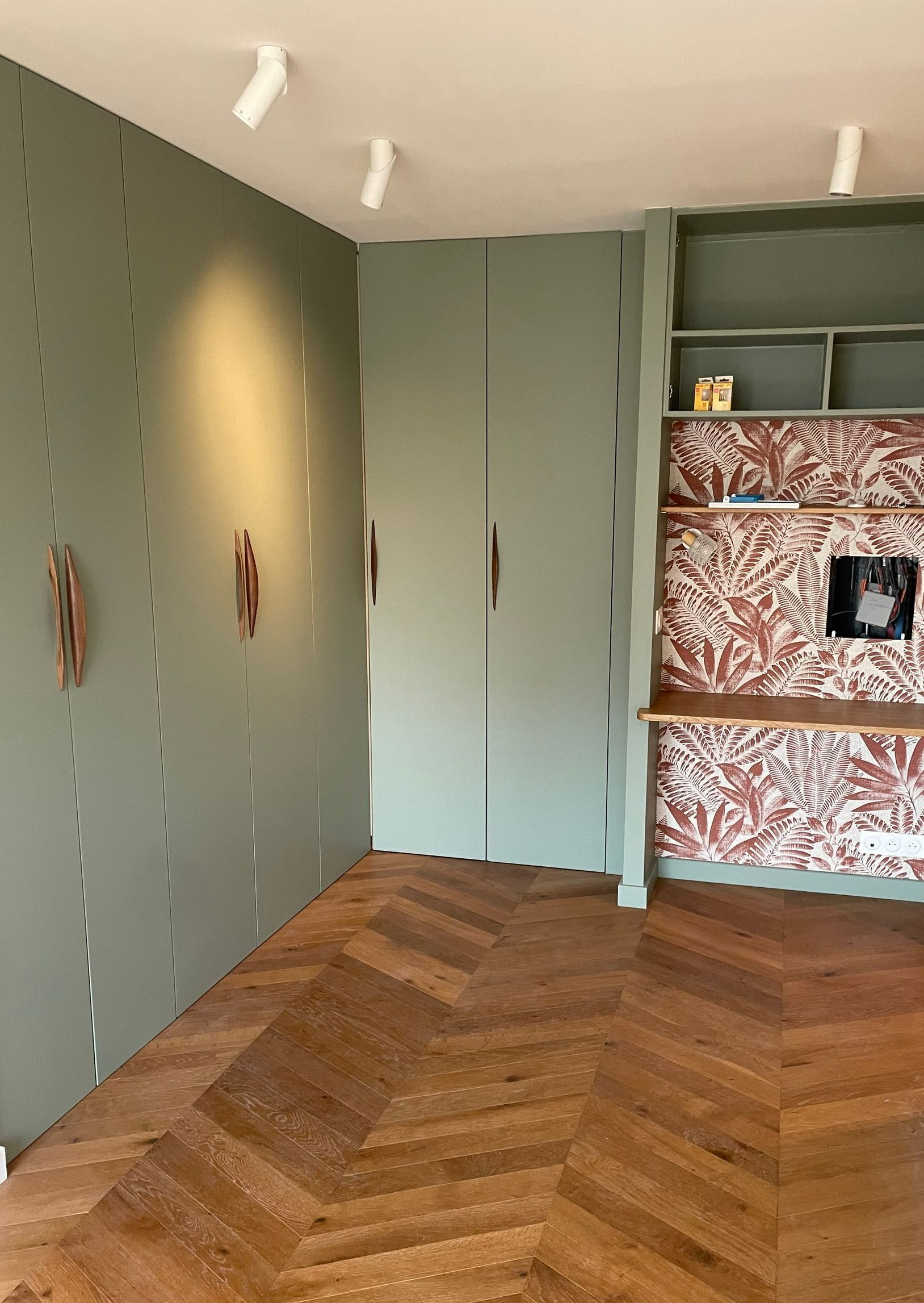 Des placards aménagés dans une chambre avec du parquet.