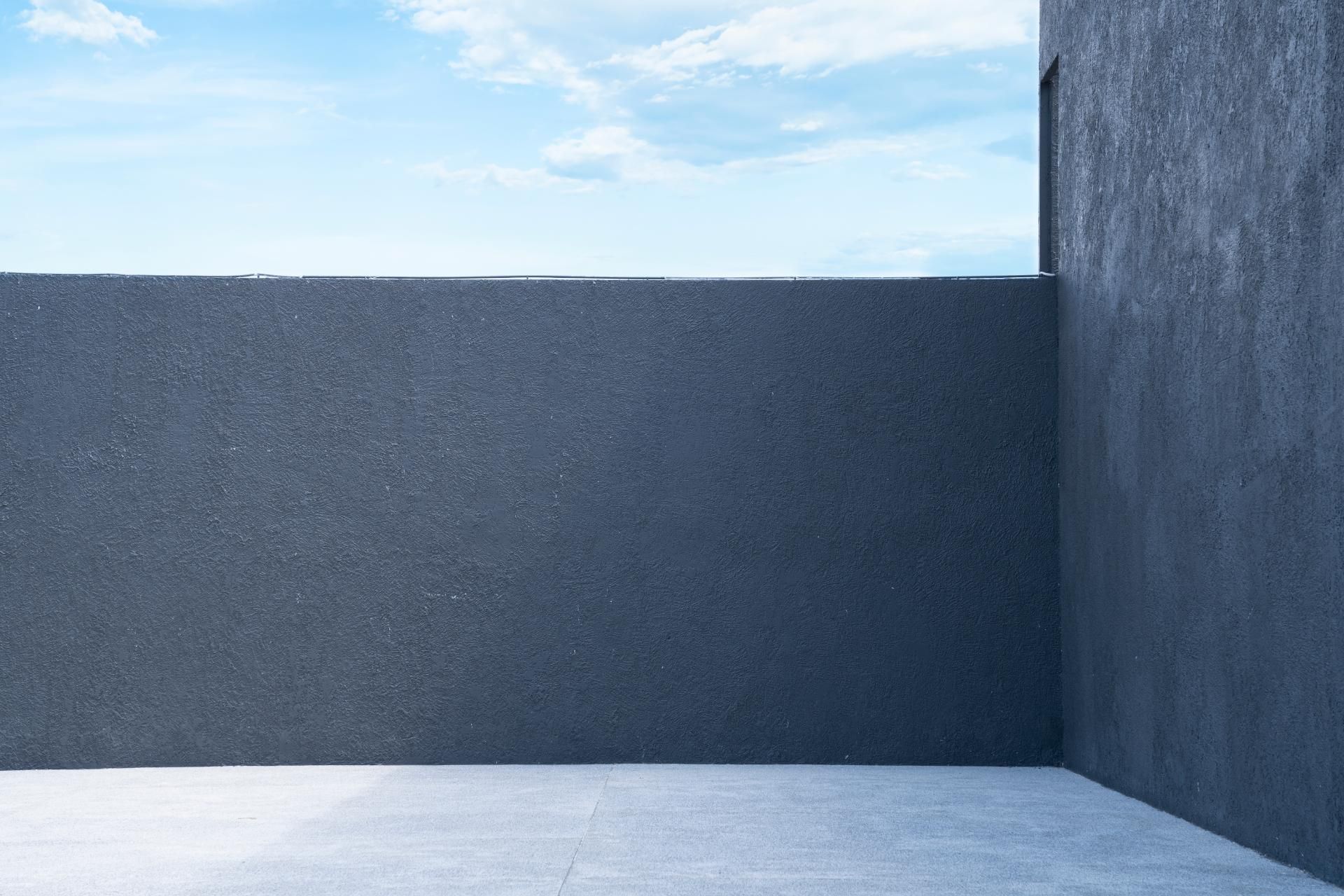 ein Raum mit einer schwarzen Wand und einem blauen Himmel dahinter