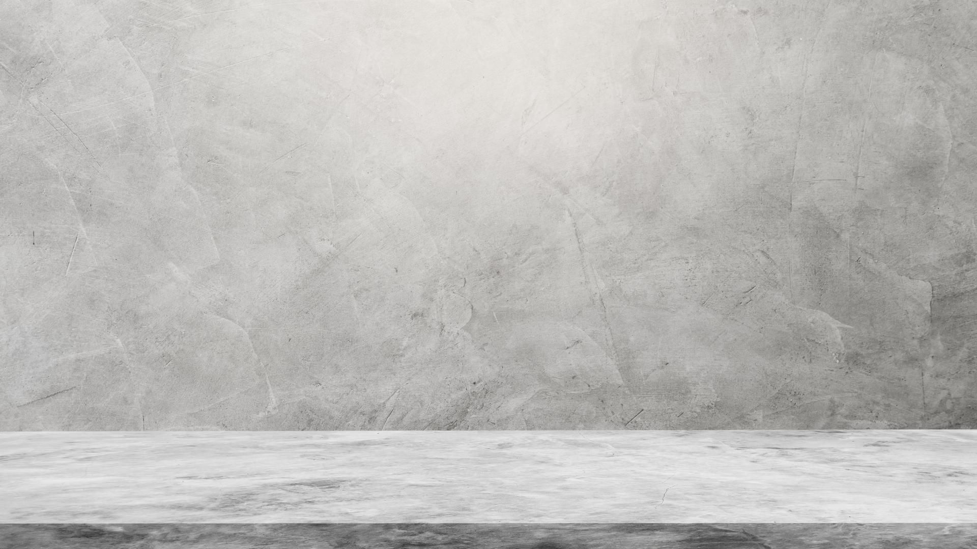 ein weißer marmortisch vor einer grauen betonwand
