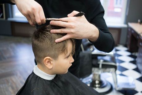 Mitarbeiterin von Coiffeur Bergita Gjidoda schneidet Kind die Haare