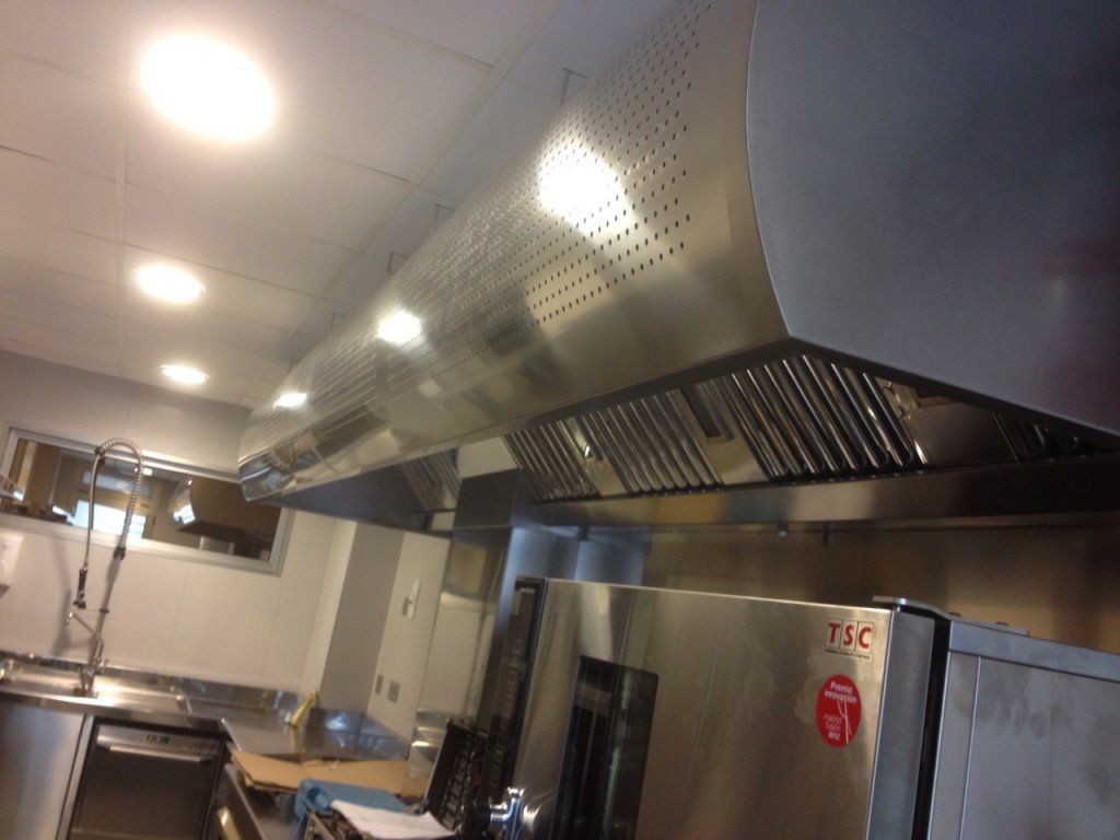 Una cocina con campana de acero inoxidable y horno tsc.