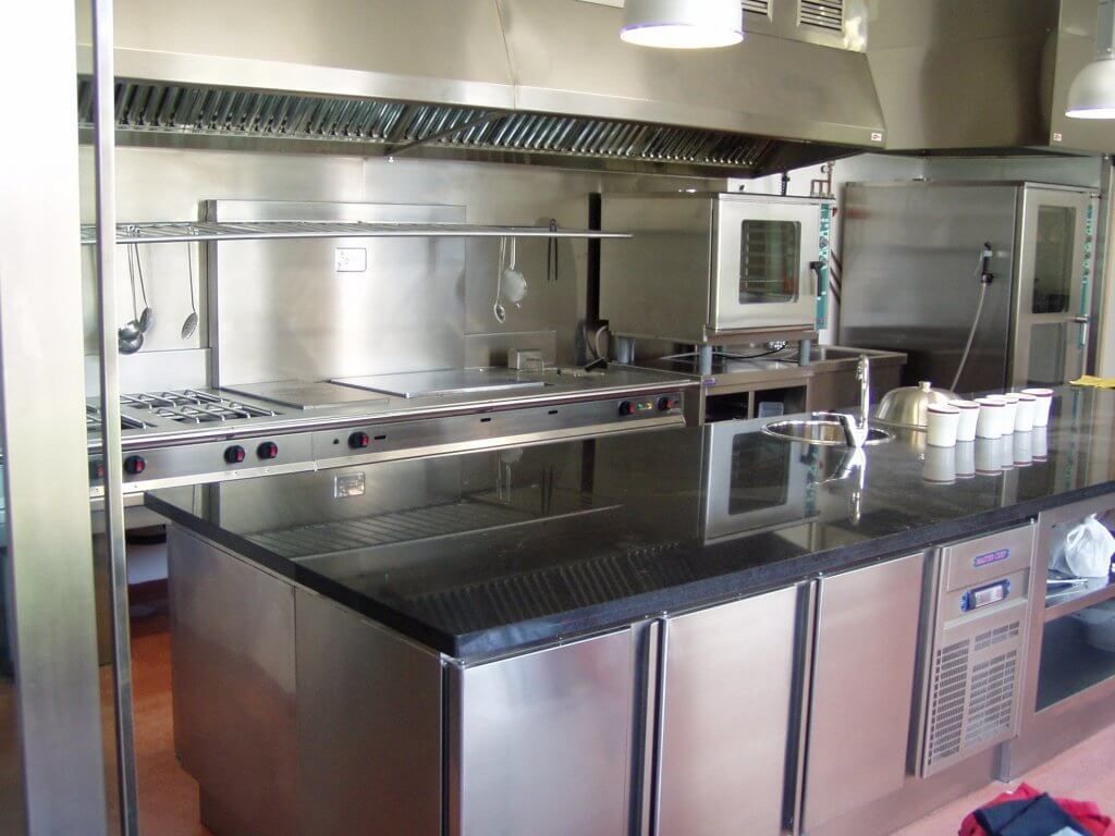 Una cocina con electrodomésticos de acero inoxidable y una encimera negra.