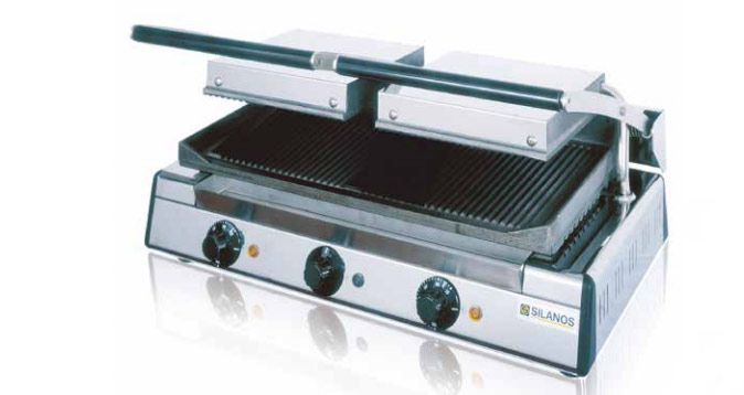 Una parrilla de acero inoxidable está sobre una superficie blanca.