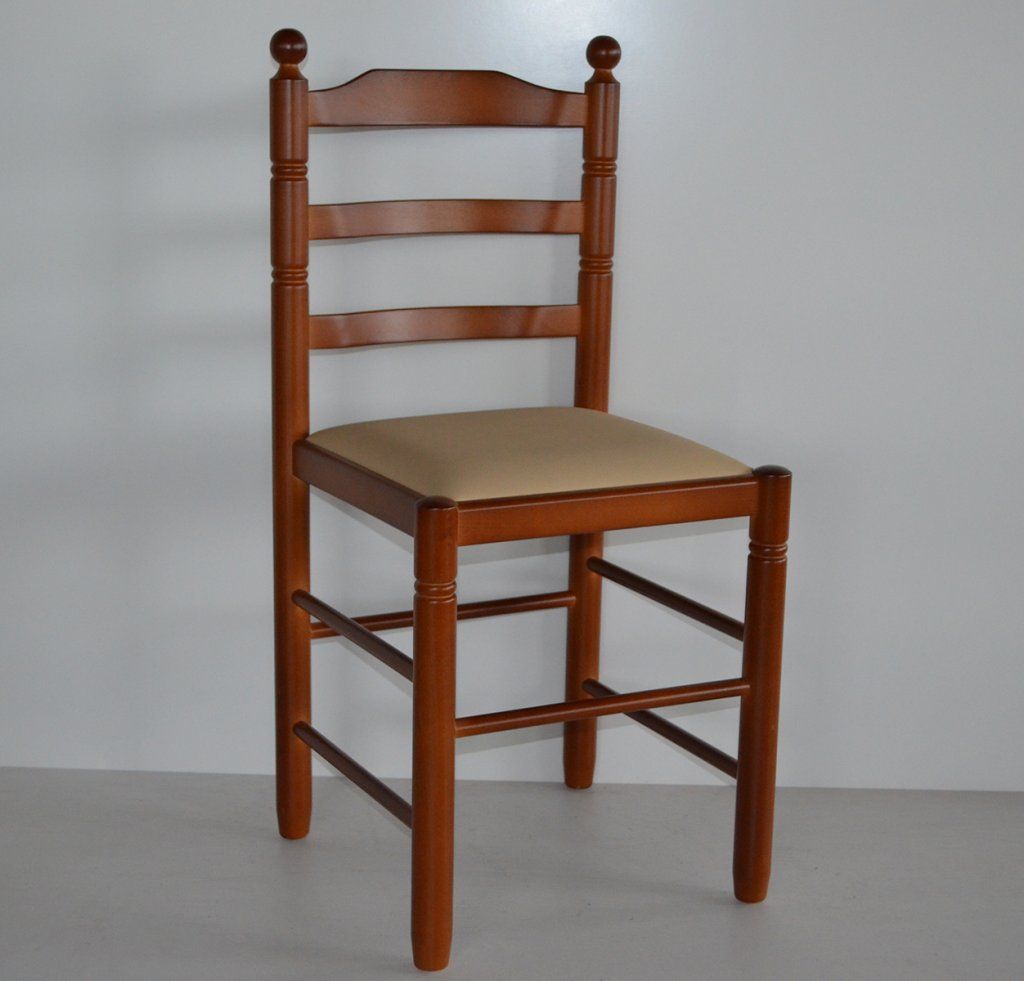 Una silla de madera con un cojín beige reposa sobre una superficie blanca.