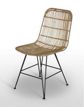 Una silla de mimbre con patas de metal está sentada sobre una superficie blanca.