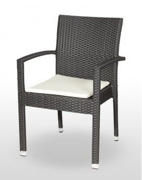 Una silla de mimbre con un cojín blanco encima.