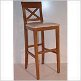 Un taburete de bar de madera con un cojín blanco está sobre una mesa.