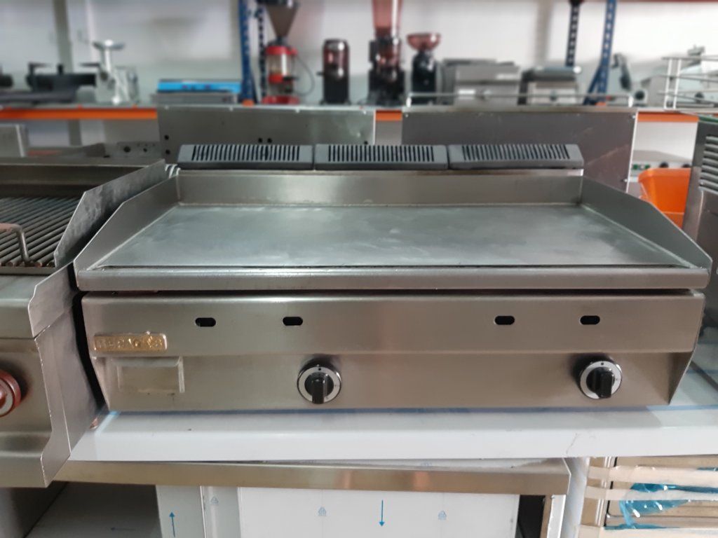 Una parrilla de acero inoxidable está sobre un mostrador en una cocina.