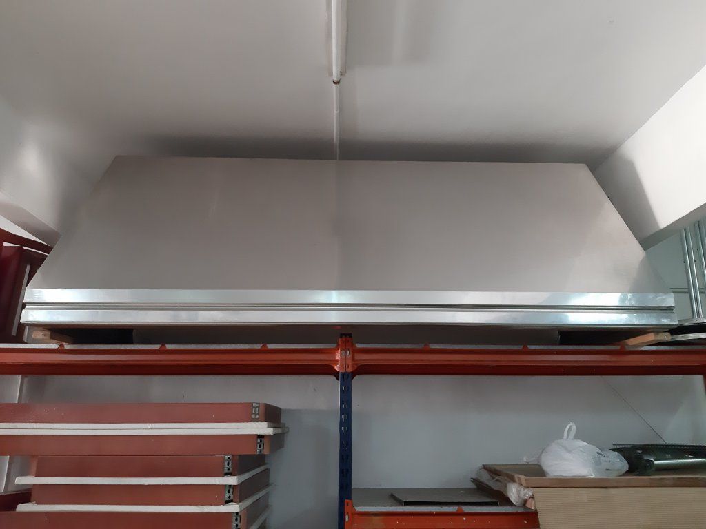 Una campana de acero inoxidable cuelga del techo de una cocina.