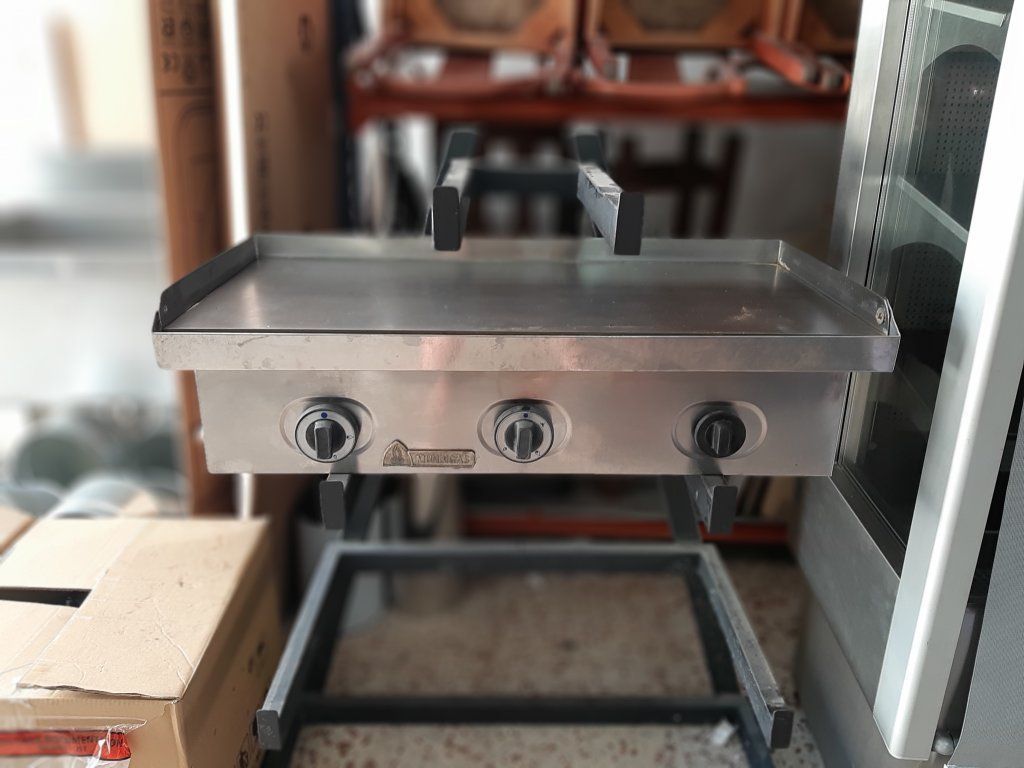 Una parrilla de acero inoxidable está colocada sobre un soporte en una habitación.