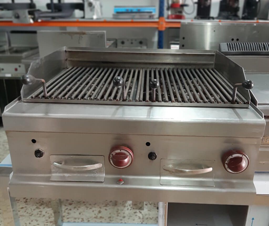 Una parrilla de acero inoxidable está sobre un mostrador en una cocina.