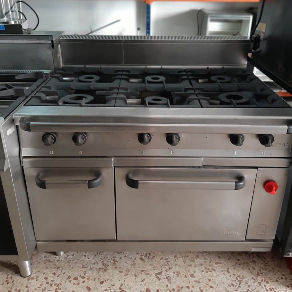 Una estufa de acero inoxidable con cuatro quemadores y un horno.