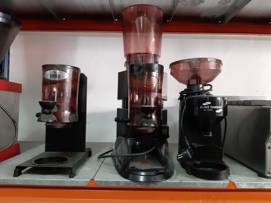 Tres molinillos de café están alineados en un estante de una tienda.