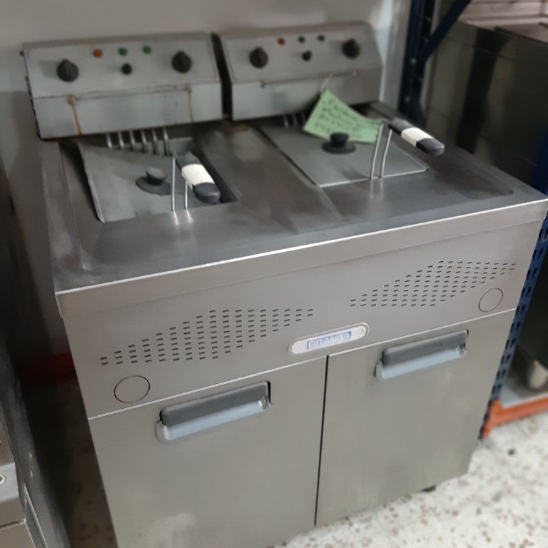 Una freidora de acero inoxidable está sobre un mostrador.