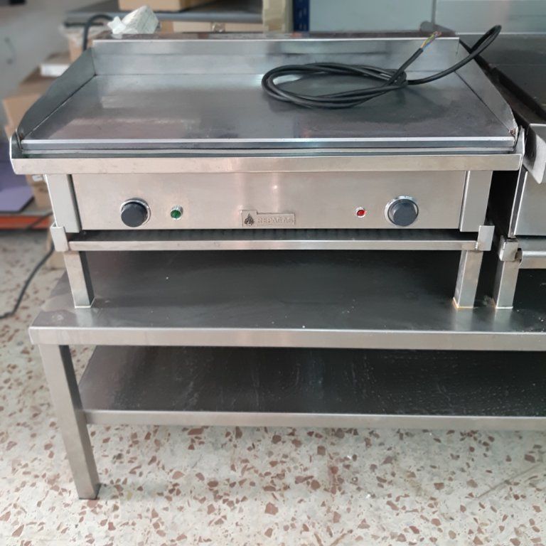 Una parrilla de acero inoxidable está colocada encima de un estante de acero inoxidable.