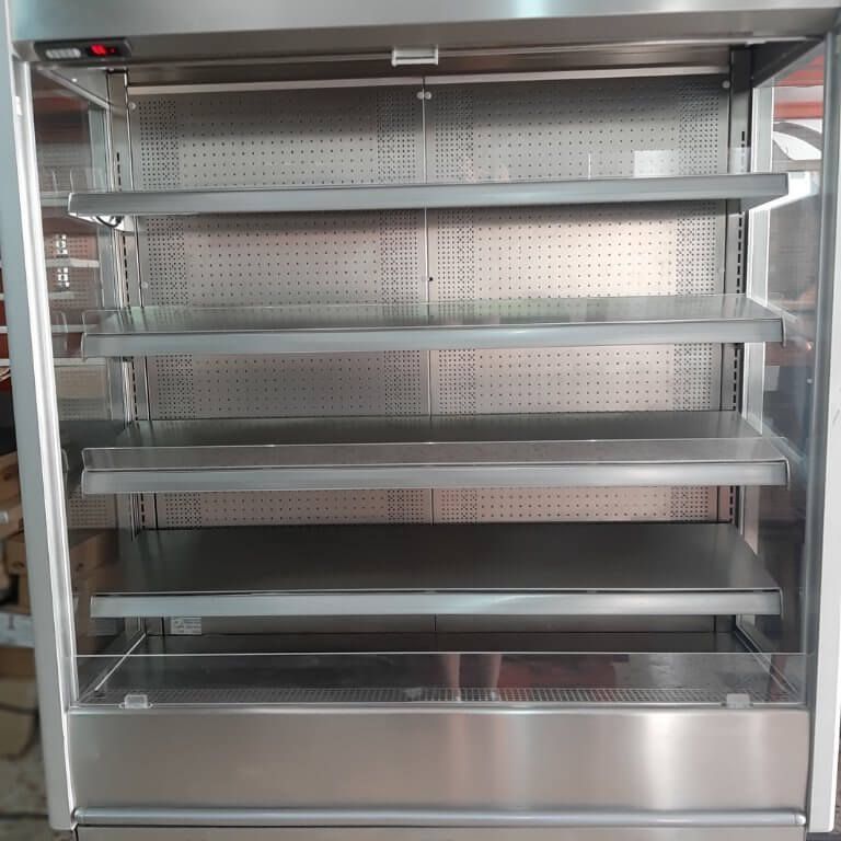 Un refrigerador de acero inoxidable vacío con estantes.