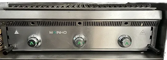 Una parrilla de acero inoxidable con tres perillas.