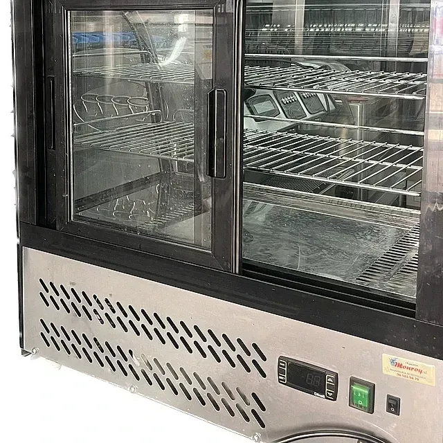 Un refrigerador de acero inoxidable con puertas y estantes de vidrio.