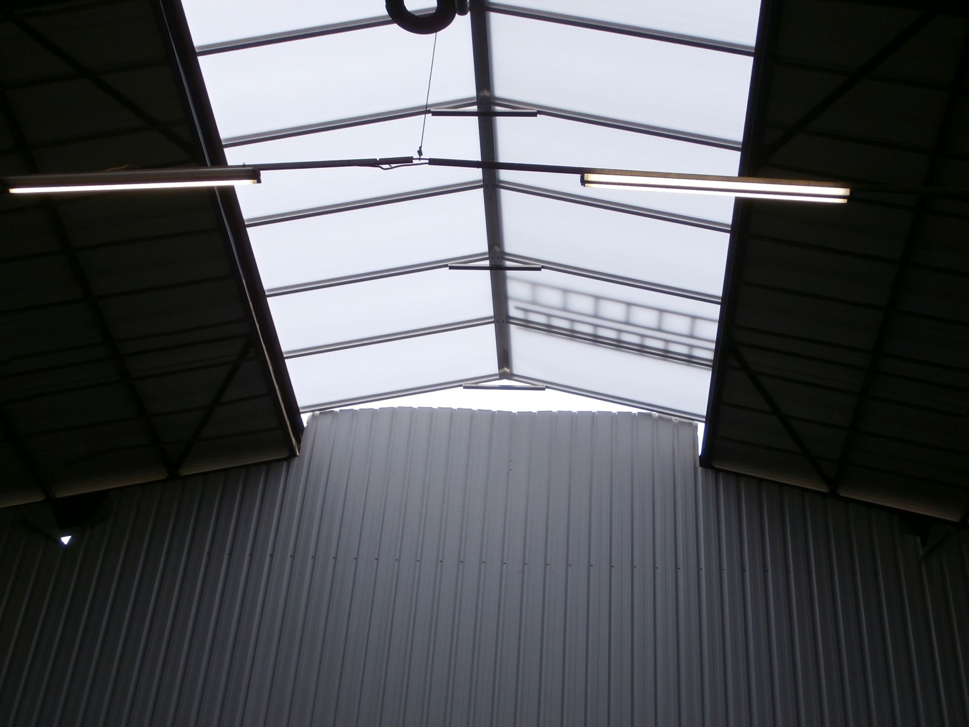 Toit métallique percé de puits de lumière.