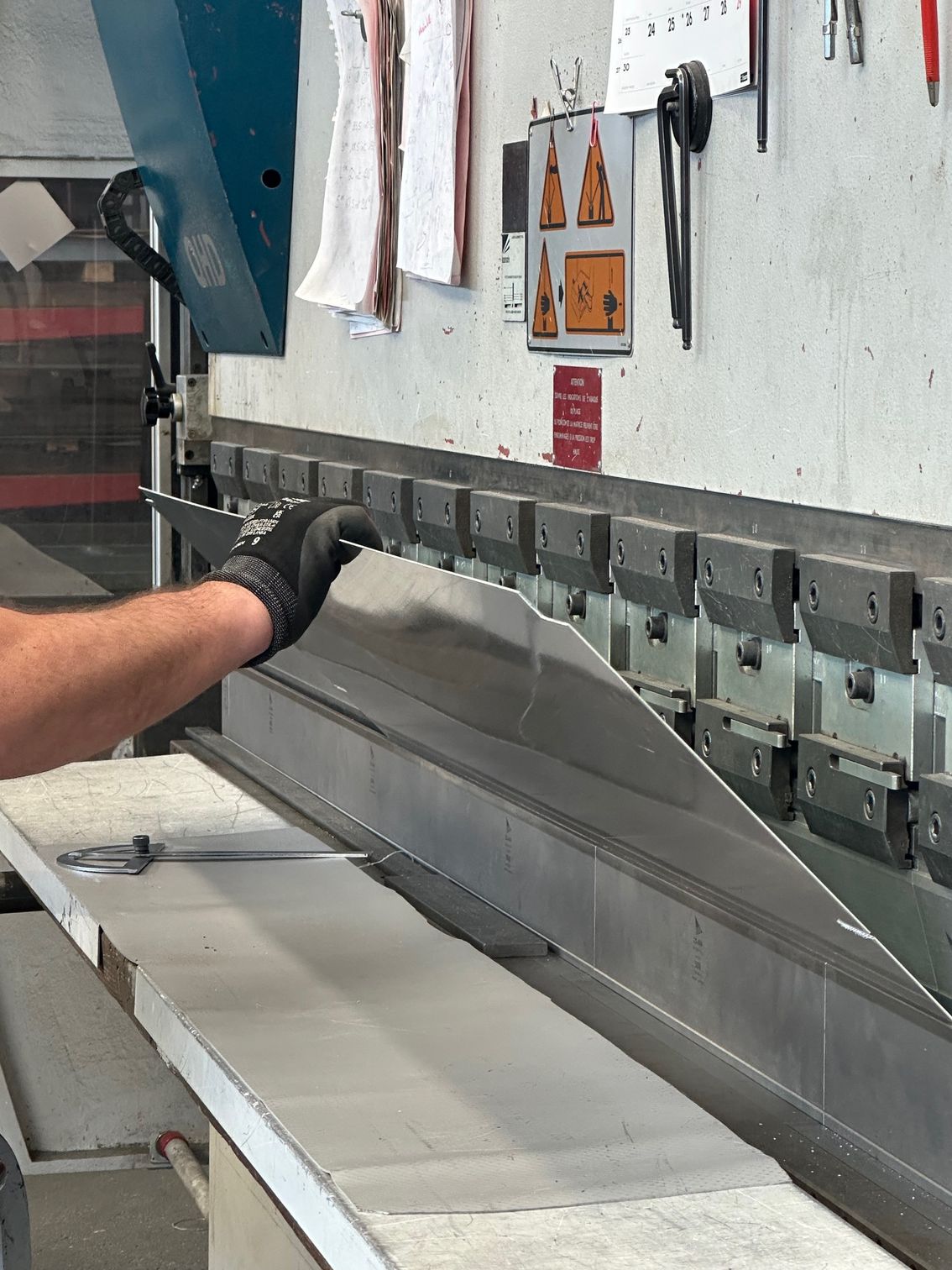 Une personne utilisant une machine à cintrer les métaux dans un atelier.