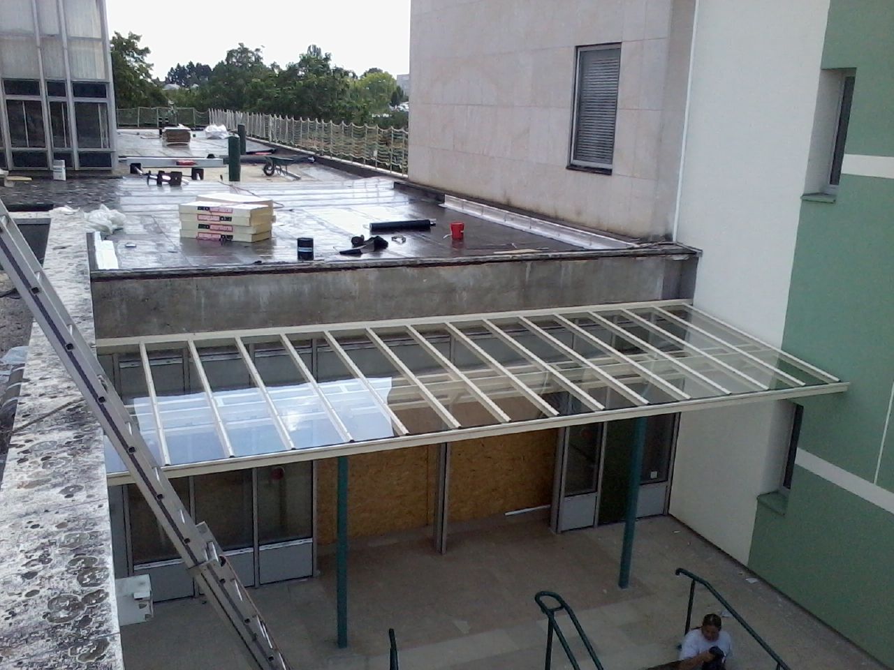 Vue aérienne d'un bâtiment avec un auvent au-dessus des portes, un toit plat.