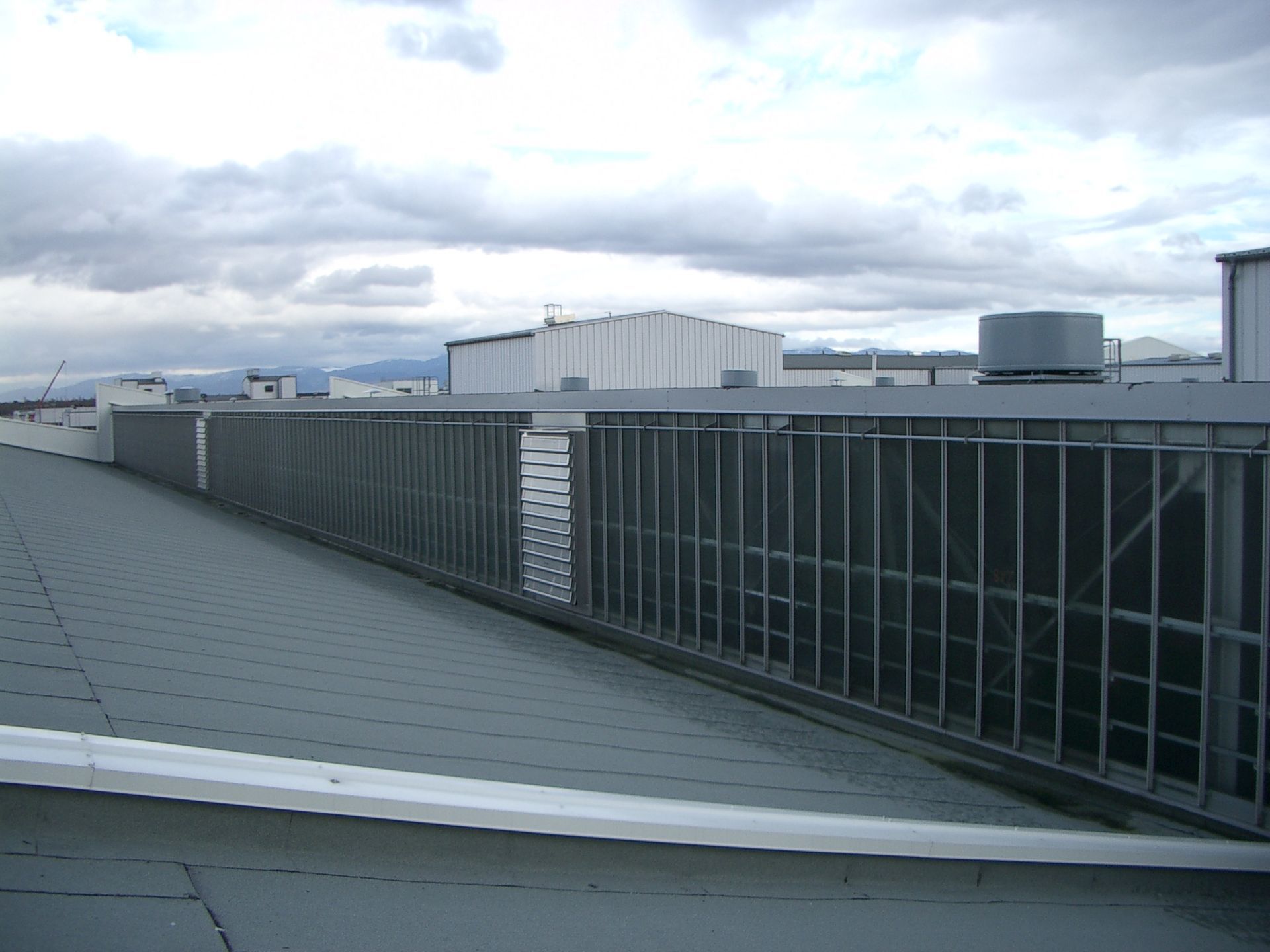 Clôture métallique longeant le bord du toit plat d'un bâtiment.