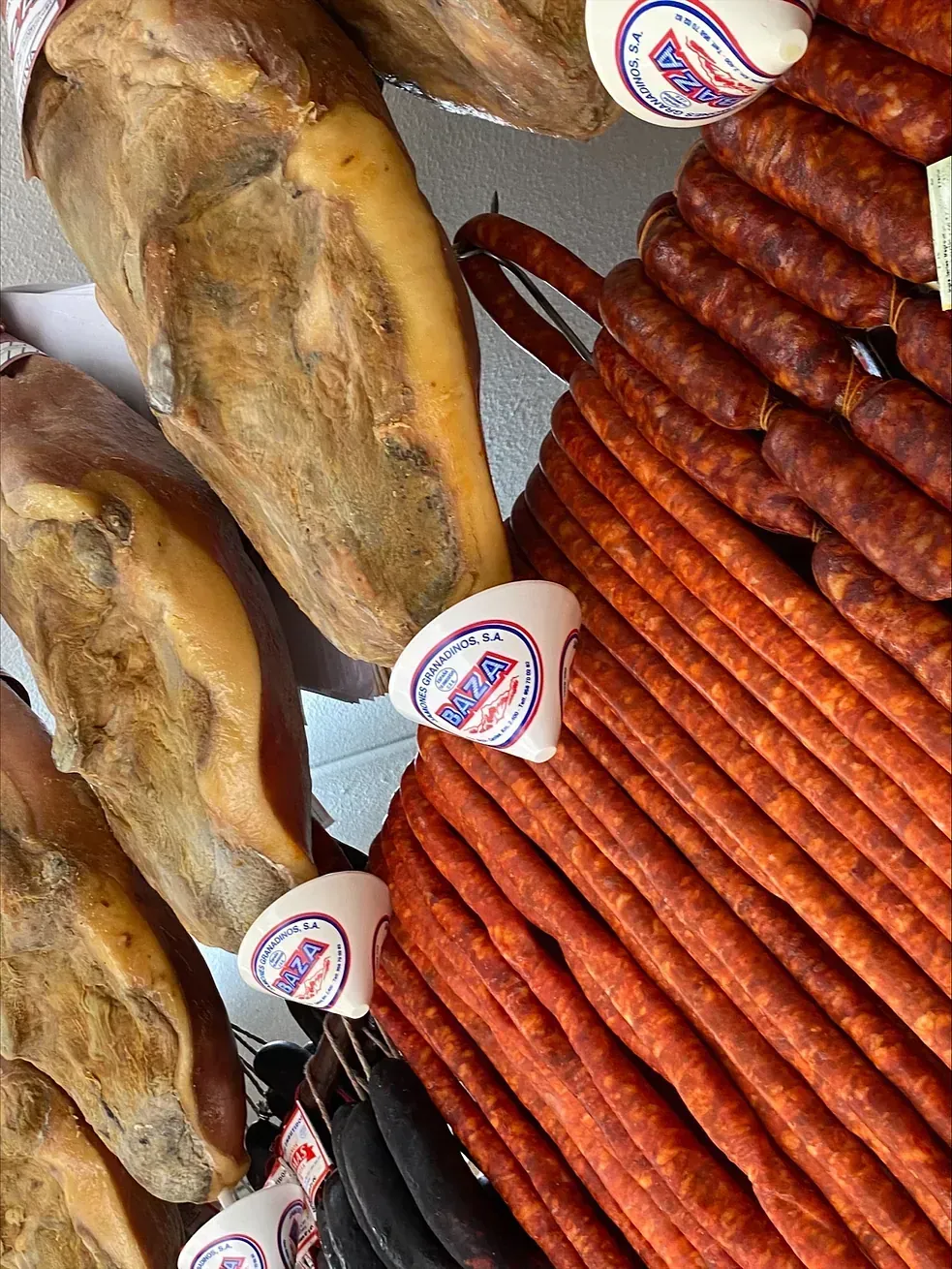Embutidos: jamón, chorizos y morcilla, colgados para su venta.