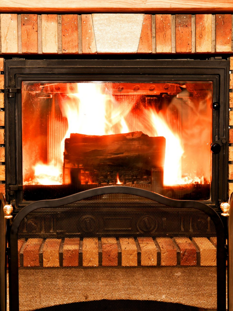 Cheminée avec un feu flamboyant, à l'intérieur d'une structure en briques.