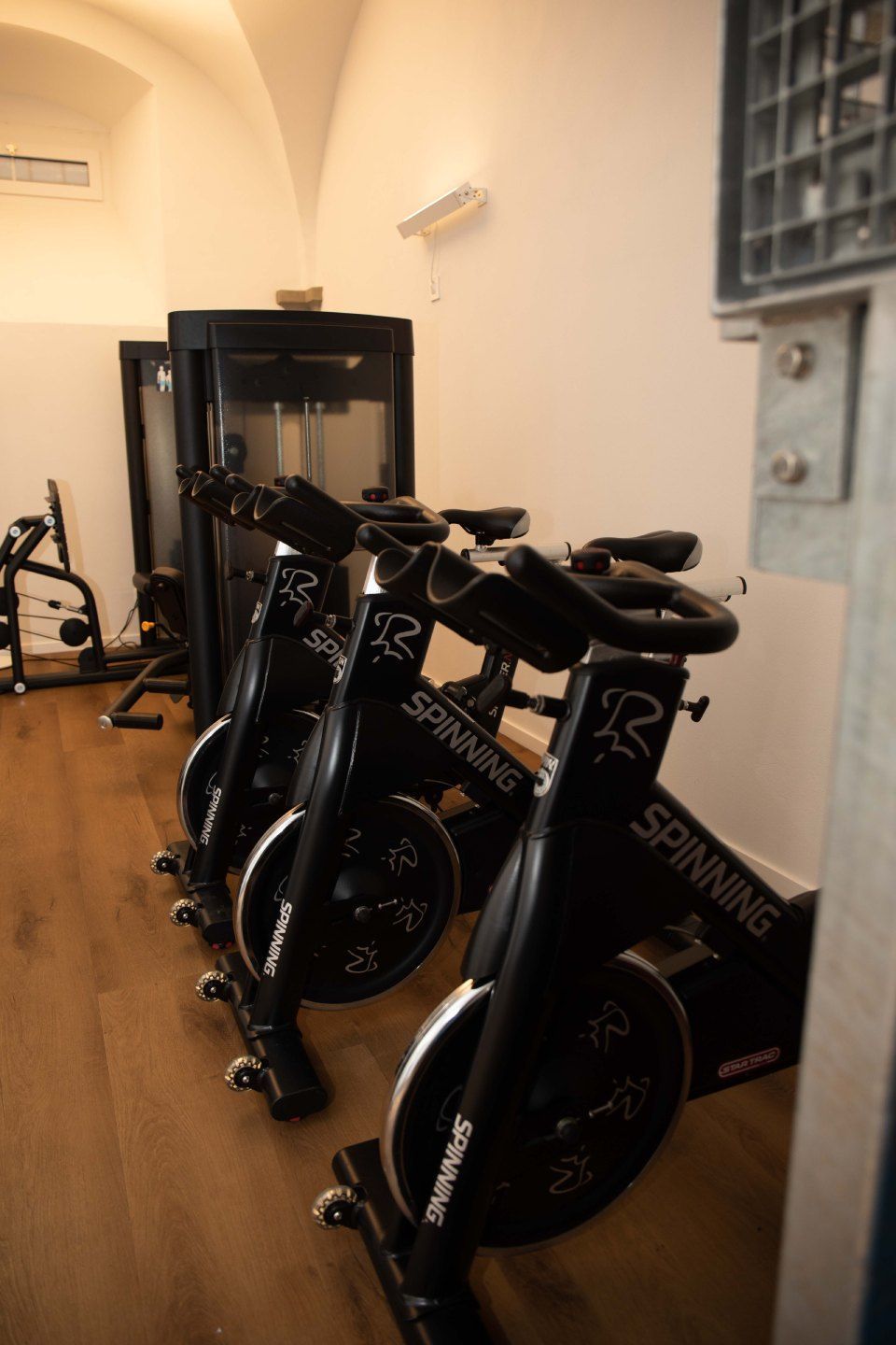 In einem Fitnessstudio standen Spinning-Bikes in Reih und Glied, dazu ein dunkel gefärbtes Gerät und ein Holzboden.
