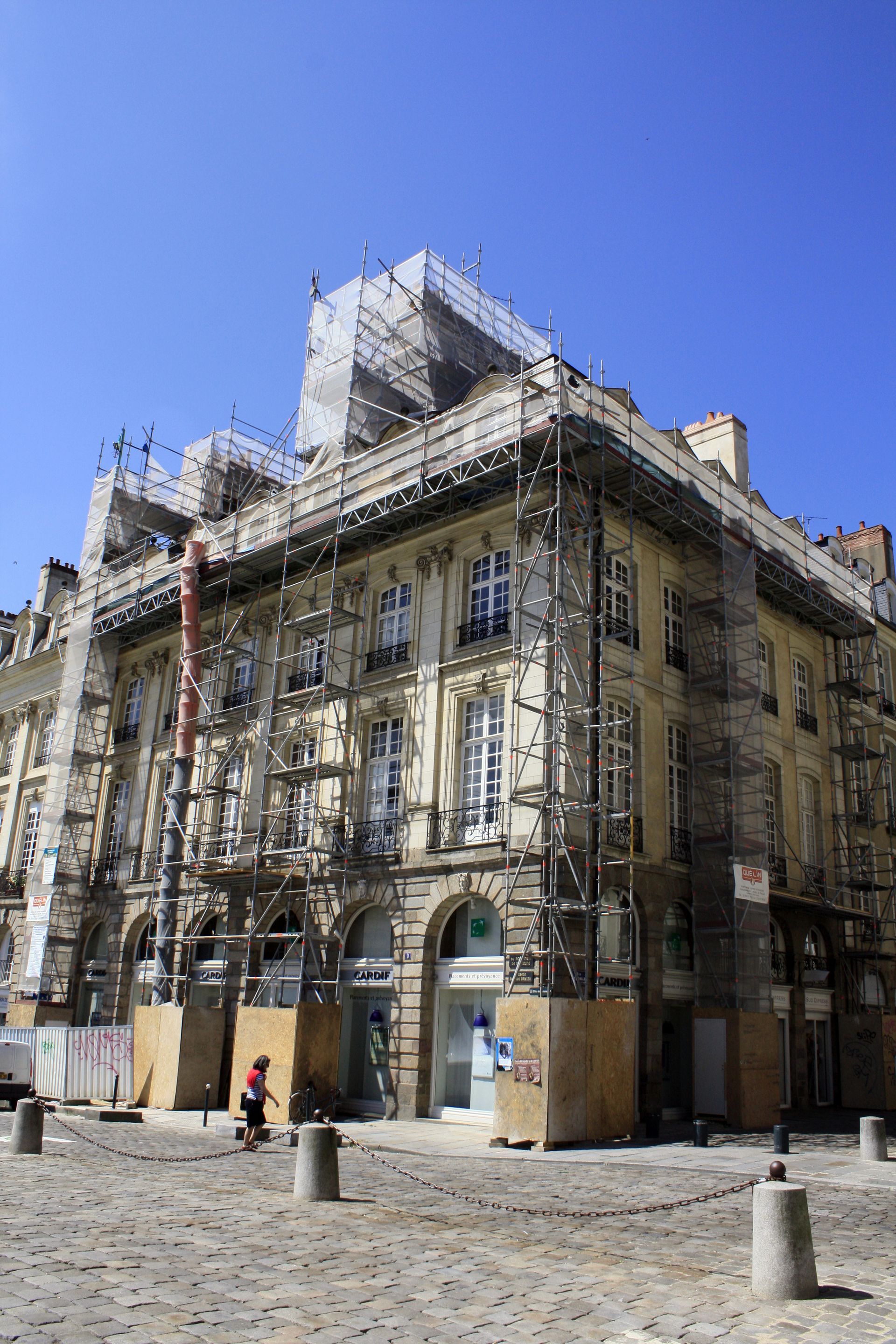Un bâtiment ancien entouré d'échafaudages métalliques.