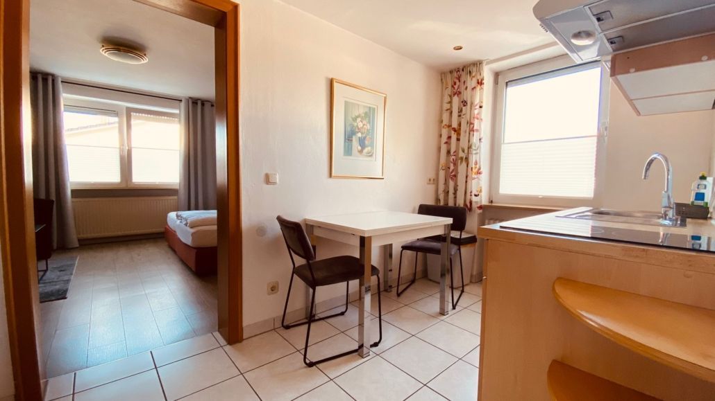 Kleines Apartment mit Essbereich und offenem Durchgang zum Schlafzimmer.