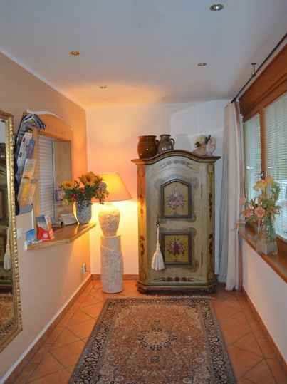 Hotelzimmer mit Bett, Schreibtisch, rotem Stuhl, Fenster und Fernseher.