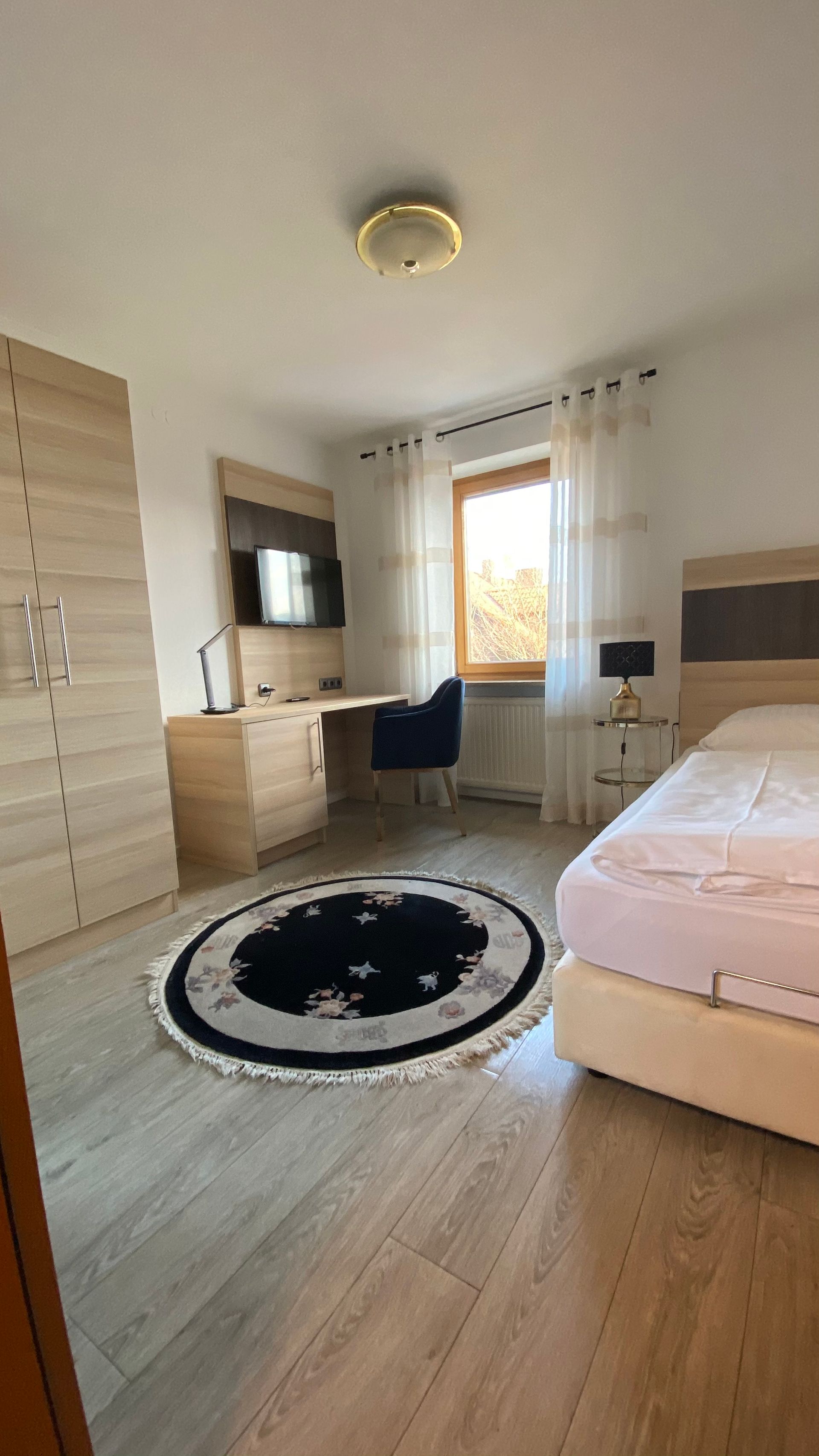 Eine Frau steht im Türrahmen eines Gebäudes, umgeben von Topfpflanzen.